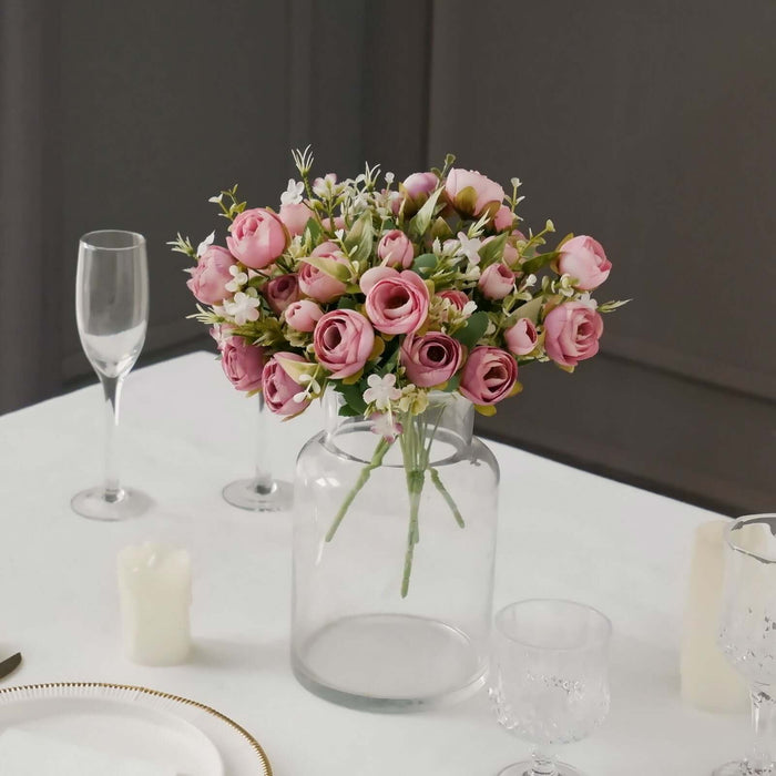 Pink rose bouquet in a clear vase on a dining table setting.
