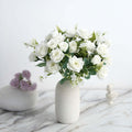 White rose bouquet in a minimalist vase on a marble surface.