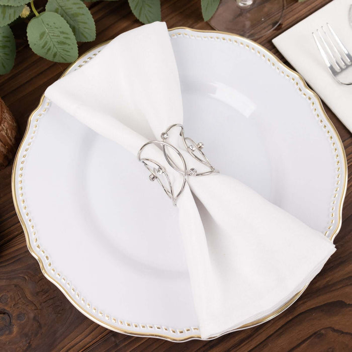 Elegant silver napkin holder on a white plate with a folded cloth napkin.