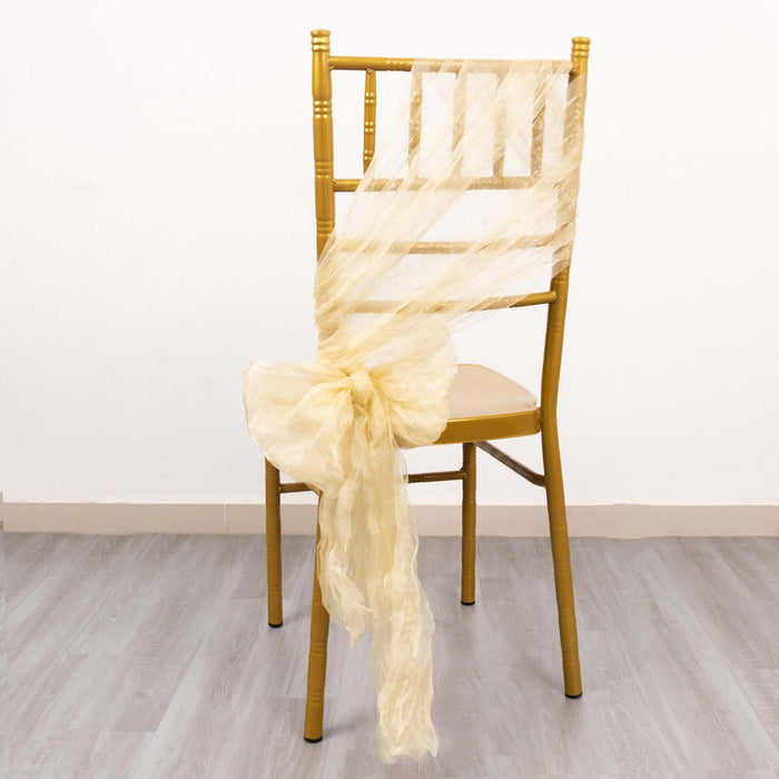 Gold chiavari chair with cream organza sash tied in a bow.