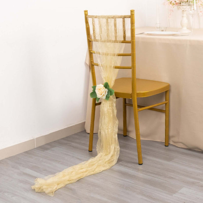 Elegant gold chair with flowy yellow fabric and rose decoration.