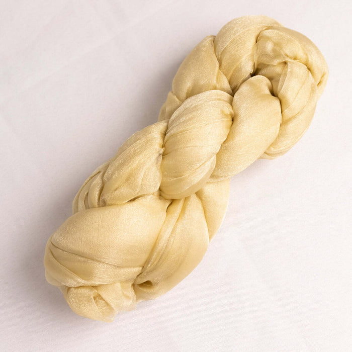 Braided golden silk yarn on a plain background. #whtbkgd
