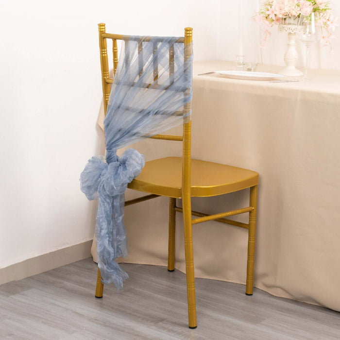 Gold chiavari chair adorned with blue tulle draping.