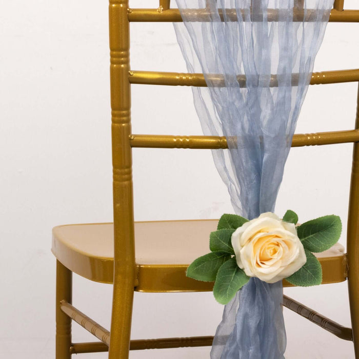 Gold chiavari chair with blue ribbon and cream rose decoration.