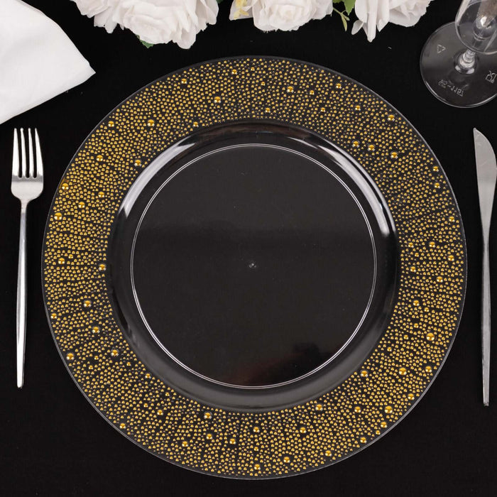 Elegant black plate with gold polka dot design on a dark table setting.