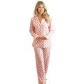 Woman wearing gingerbread blush long pajama set with floral pattern, standing against white background