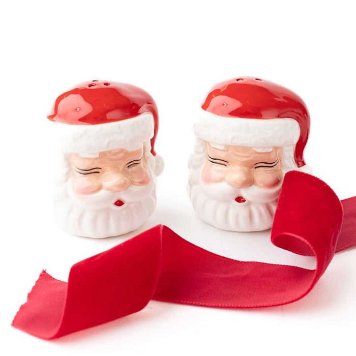 Red and white ceramic Santa Claus salt and pepper shaker set with red ribbon bow on white background
