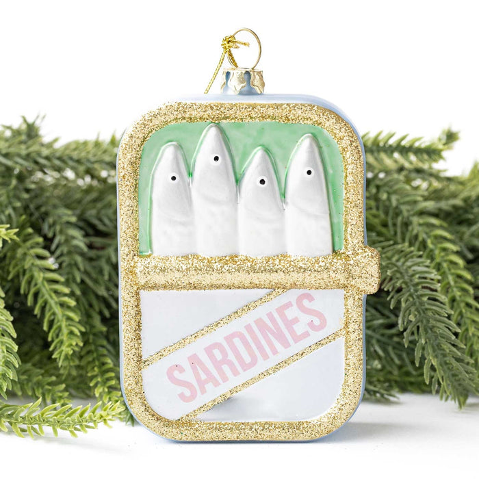 Gold glitter sardine tin ornament displayed among evergreen branches