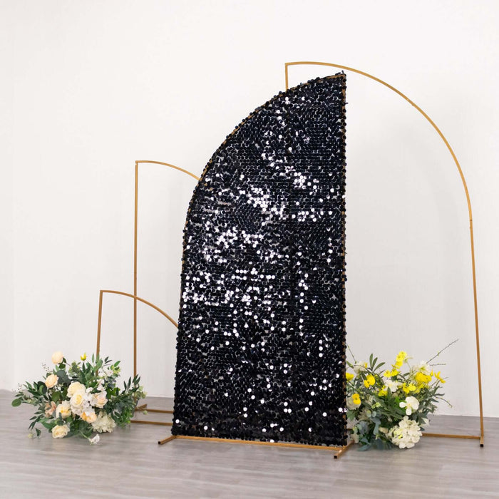 Black sequin backdrop with gold arch and floral arrangement.