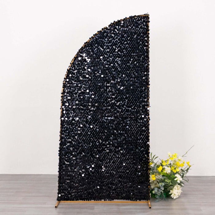 Black sequined room divider with a curved top and floral arrangement beside it.