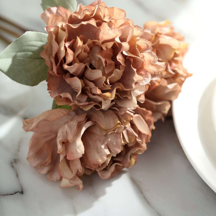 Dried peach peonies arranged elegantly on a marble surface.