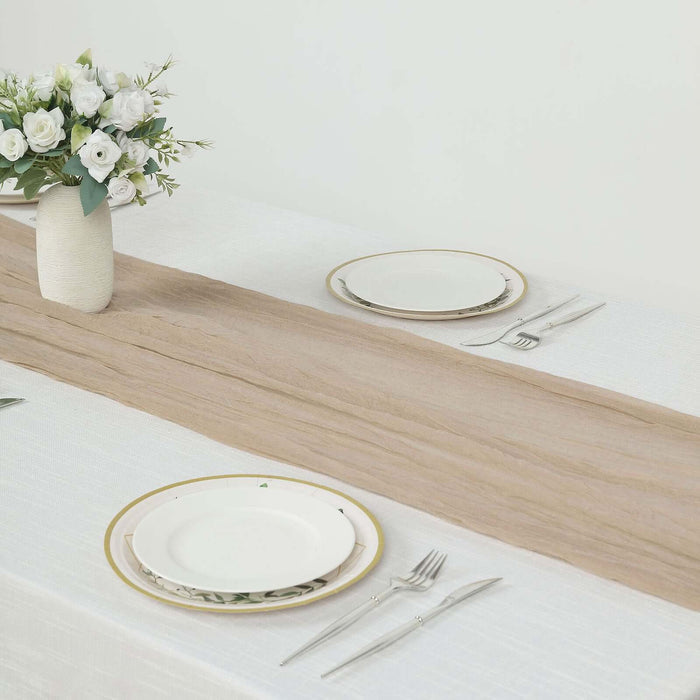 Neutral table setting with white plates, cutlery, and a floral centerpiece.
