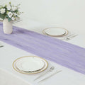 Lavender table runner on a dining table with plates and floral centerpiece.