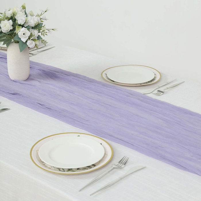 Lavender table runner on a dining table with plates and floral centerpiece.