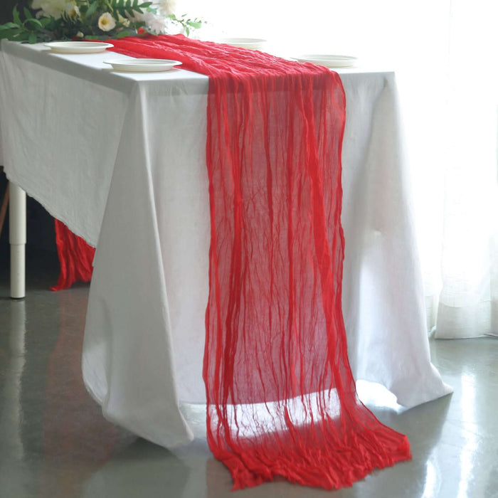Red table runner draped elegantly over a white table setting.