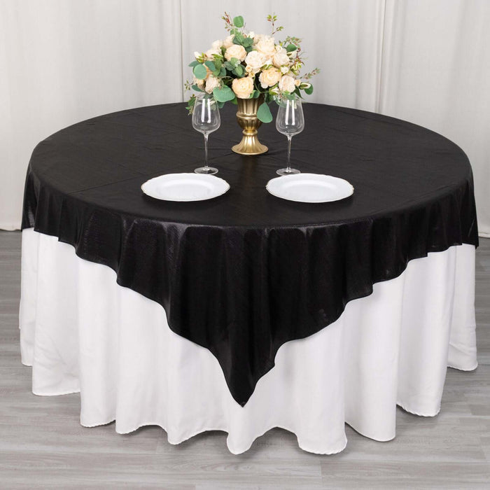 Black and white tablecloth with floral centerpiece and dinnerware set.