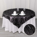 Black sheer table overlay with silver accents on a round table
